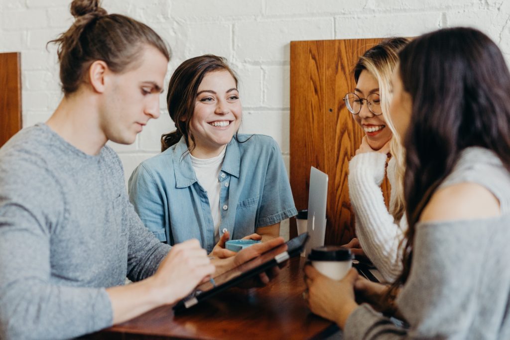 Four friends in a coffee shop chatting about their favorite brands