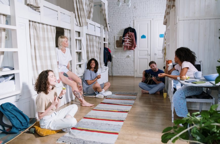 students smiling and chatting around bunk beds